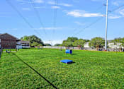 Thumbnail 35 of 39 - A grassy field with a blue object in the middle and a pole on the right.