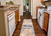 Thumbnail 6 of 20 - A kitchen with white appliances and wooden cabinets.