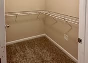 Thumbnail 11 of 20 - Empty walk-in closet with white shelves and carpeted floor.
