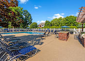 Thumbnail 2 of 29 - a swimming pool with blue lounge chairs and umbrellas
