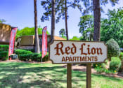 Thumbnail 8 of 20 - a red lion apartments sign in front of a yard with trees