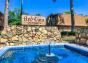 Thumbnail 5 of 20 - a pool with a fountain in front of the red lion apartments sign