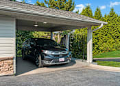 Thumbnail 23 of 29 - a car parked in a carport in front of a house