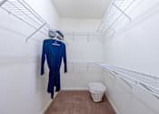 Thumbnail 19 of 29 - a walk in closet with a dress hangar and a trash can