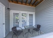 Thumbnail 24 of 29 - a covered porch with two chairs and a table