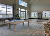 Thumbnail 8 of 42 - A billiard table in a room with a view of a building outside the window.