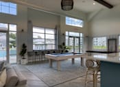 Thumbnail 9 of 42 - A room with a pool table and a view of a street outside.