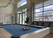 Thumbnail 12 of 42 - A pool table with a blue cloth and a white cue ball and red, white and blue balls on it.