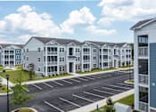 Thumbnail 30 of 42 - A large building with a parking lot in front of it.