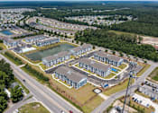 Thumbnail 28 of 42 - A bird's eye view of a residential complex with a lake in the middle.
