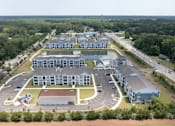 Thumbnail 40 of 42 - An aerial view of a large building complex surrounded by trees.