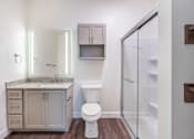 Thumbnail 43 of 52 - A white toilet sits next to a sink in a bathroom.