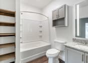 Thumbnail 44 of 52 - A white toilet sits next to a bathtub in a bathroom.