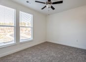 Thumbnail 41 of 54 - A room with a ceiling fan and carpeted floor.