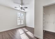 Thumbnail 43 of 54 - A room with a ceiling fan and a window with blinds.