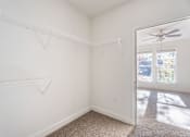 Thumbnail 47 of 52 - A white room with a carpet floor and a ceiling fan.