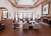 Thumbnail 17 of 20 - A large, well-lit living room with a fireplace and a chandelier.
