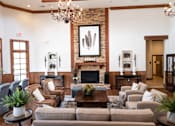 Thumbnail 16 of 20 - A living room with a fireplace and a chandelier.