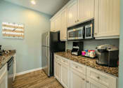 Thumbnail 7 of 21 - a kitchen with white cabinets and a black refrigerator