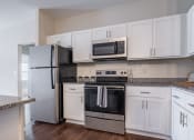 Thumbnail 11 of 32 - a kitchen with white cabinets and stainless steel appliances