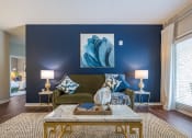 Thumbnail 17 of 32 - a living room with blue accent wall and a green couch