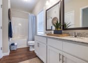 Thumbnail 27 of 32 - a bathroom with white cabinets and a sink and a toilet