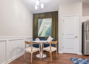 Thumbnail 13 of 32 - a dining room with a table and chairs and a refrigerator
