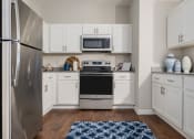 Thumbnail 9 of 32 - a kitchen with stainless steel appliances and white cabinets
