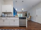 Thumbnail 12 of 32 - a kitchen with white cabinets and a stainless steel dishwasher