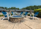 Thumbnail 5 of 32 - a fire pit with blue chairs and chairs around it