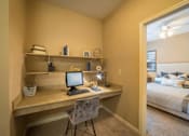 Thumbnail 18 of 21 - a bedroom with a desk with a computer and a bed