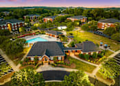 Thumbnail 1 of 24 - A large building with a pool in front of it.