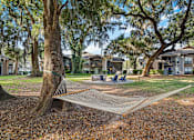 Thumbnail 8 of 33 - firepit and lounge area with hammocks under beautiful south carolina trees