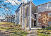 Thumbnail 17 of 19 - A modern apartment building with a central staircase leading to the upper floors at Heights at New Garden apartments in Greensboro, NC.