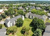 Thumbnail 19 of 19 - A bird's eye view of a residential area with houses and trees at Heights at New Garden apartments in Greensboro, NC.