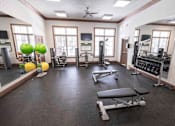 Thumbnail 19 of 20 - A gym with a variety of equipment including weights and exercise balls.