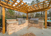 Thumbnail 3 of 21 - a covered patio with two bbq pits under a wooden roof