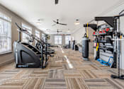 Thumbnail 15 of 52 - A gym with a variety of equipment including treadmills, weights, and a punching bag.