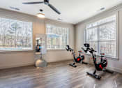 Thumbnail 20 of 54 - A room with a fan, exercise bikes, and a large window.