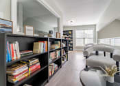 Thumbnail 25 of 40 - a living room with a bookshelf filled with books    and chairs