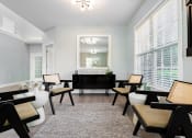 Thumbnail 26 of 40 - a living room with white walls and a black table and chairs