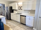 Thumbnail 3 of 15 - A kitchen with white cabinets and a black refrigerator at River Ridge Apartments in Asheville, NC