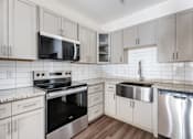 Thumbnail 30 of 52 - A kitchen with white cabinets and a stainless steel dishwasher.