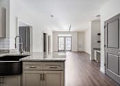 Thumbnail 32 of 52 - A kitchen with a black counter top and wooden floors.