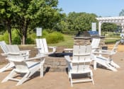 Thumbnail 27 of 35 - a group of white chairs sitting around a fire pit