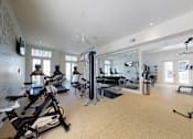 Thumbnail 11 of 19 - A spacious gym with a variety of equipment including treadmills, stationary bikes, and weight machines.