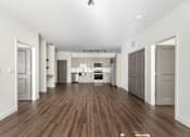 Thumbnail 35 of 54 - A spacious kitchen with white walls and a wooden floor.
