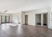Thumbnail 34 of 52 - A room with wooden floors and white walls.