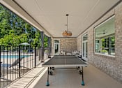 Thumbnail 7 of 52 - A ping pong table is in the middle of a covered patio.