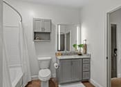 Thumbnail 26 of 52 - A bathroom with a white toilet, a sink with a mirror above it, and a shower with a white curtain.